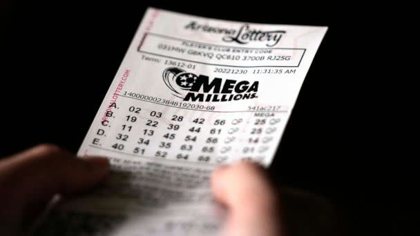 PHOTO: A person holds a Mega Millions lottery ticket in Tempe, Ariz., on Dec. 30, 2022. (Ross D. Franklin/AP)