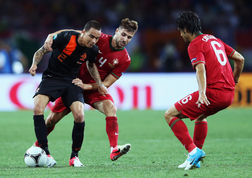 KHARKOV, UKRAINE - JUNE 17: Gregory van der Wiel (L) of Netherlands battles for the ball with Miguel Veloso of Portugal during the UEFA EURO 2012 group B match between Portugal and Netherlands at Metalist Stadium on June 17, 2012 in Kharkov, Ukraine. (Photo by Julian Finney/Getty Images)