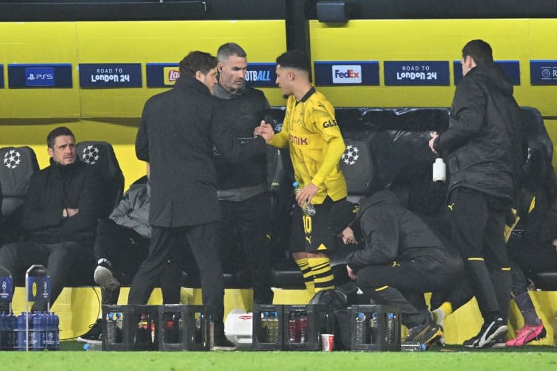 Borussia Dortmund's Jadon Sancho (C) is clapped off by coach Edin Terzic (L) during the UEFA Champions League Round of 16, second leg soccer match between Borussia Dortmund and PSV Eindhoven at Signal Iduna Park. Bernd Thissen/dpa