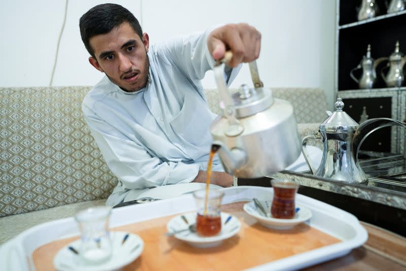 Ahmad al-Enezi, a stateless frontline worker pours tea at his home in Sulaibiya