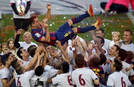 Barcelona's captain Xavi Hernandez is tossed by his teammates at Camp Nou stadium in Barcelona, Spain, May 23, 2015. REUTERS/Albert Gea