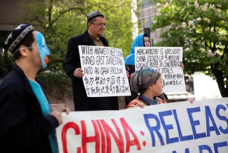 FILE PHOTO: People hold signs protesting China's treatment of Uighur people in the Xinjiang region, in Vancouver, British Columbia, Canada