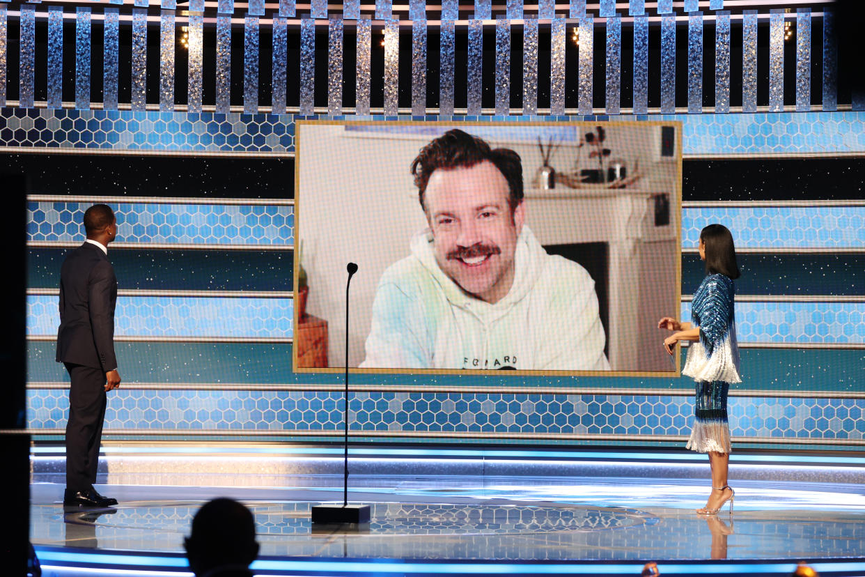 BEVERLY HILLS, CALIFORNIA: 78th Annual GOLDEN GLOBE AWARDS -- Pictured: Jason Sudeikis (c) accepts the Best Television Actor – Musical/Comedy Series award for ‘Ted Lasso’ via video from Sterling K. Brown (l) and Susan Kelechi Watson onstage at the 78th Annual Golden Globe Awards held at The Beverly Hilton and broadcast on February 28, 2021 in Beverly Hills, California. -- (Photo by Christopher Polk/NBC/NBCU Photo Bank via Getty Images)