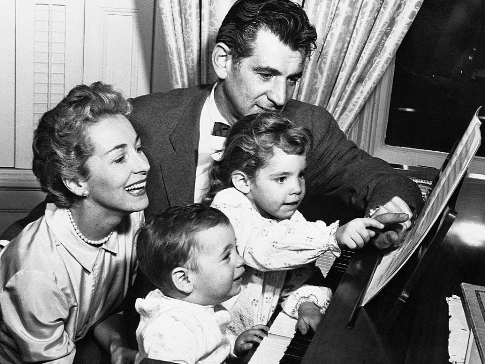Leonard Bernstein, Felicia Montealegre and their two children at a piano