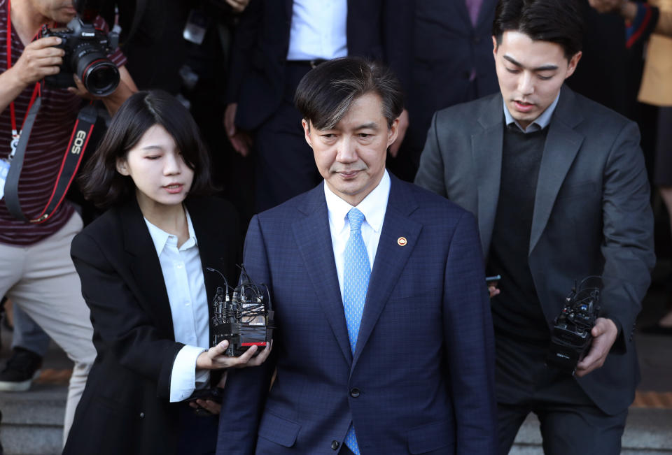 FILE -In this Monday, Oct. 14, 2019, file photo, South Korean Justice Minister Cho Kuk, center, leaves the Gwacheon Government Complex in Gwacheon. South Korean prosecutors have summoned the country’s former justice minister as they expand an investigation into corruption allegations surrounding his family that sparked huge protests.(Ryu Hyung-suck/Yonhap via AP, File)