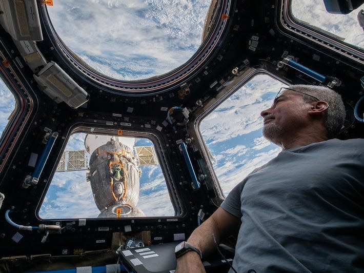 An astronaut inside ISS looking at Earth