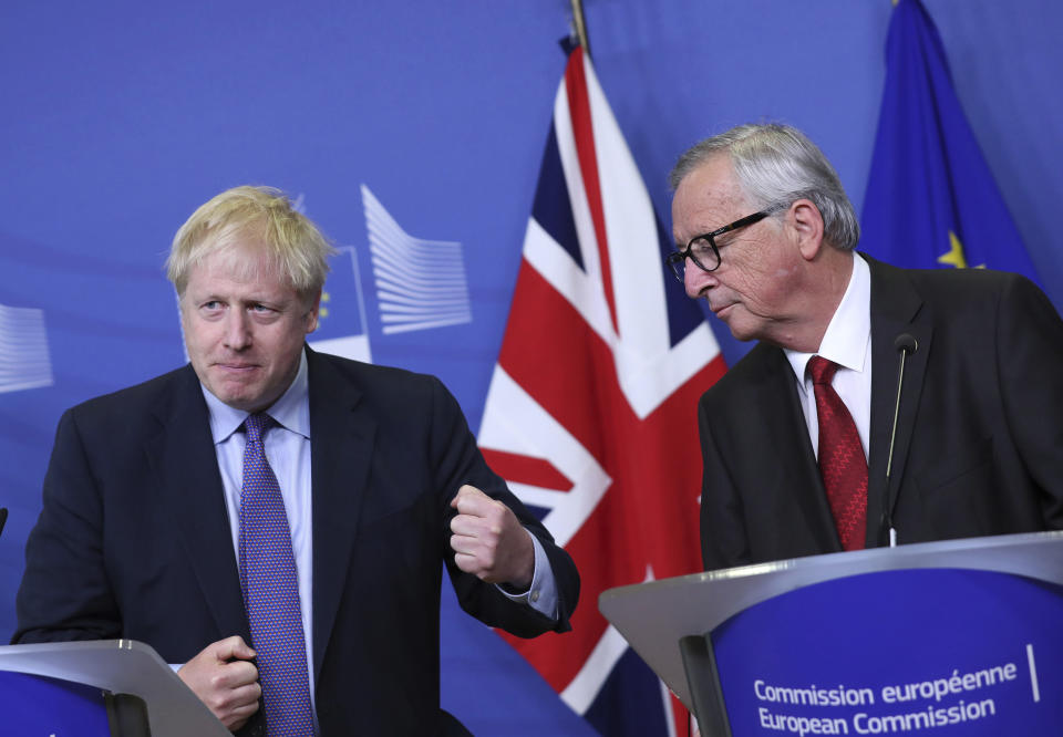 British Prime Minister Boris Johnson gestures as he stands alongside European Commission President Jean-Claude Juncker during a press point at EU headquarters in Brussels, Thursday, Oct. 17, 2019. Britain and the European Union reached a new tentative Brexit deal on Thursday, hoping to finally escape the acrimony, divisions and frustration of their three-year divorce battle. (AP Photo/Francisco Seco)