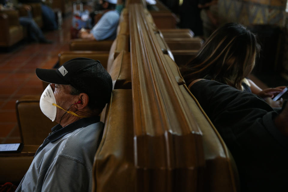 Sam Samusi, left, wears an N95 mask while waiting for his train at Union Station in Los Angeles, Monday, July 6, 2020. The coronavirus is blamed for over a half-million deaths worldwide, including more than 130,000 in the U.S., according to the tally kept by Johns Hopkins University. (AP Photo/Jae C. Hong)