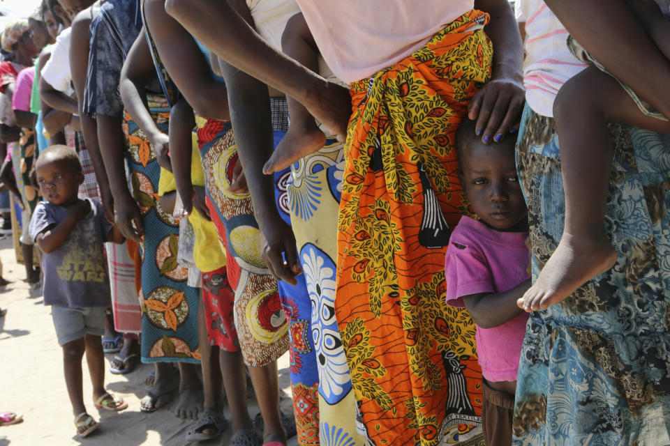 Women and children wait in a queue for oral cholera vaccinations, at a camp for displaced survivors of cyclone Idai in Beira, Mozambique, Wednesday, April 3, 2019. A cholera vaccination campaign is kicking off to reach nearly 900,000 cyclone survivors in Mozambique as officials rush to contain an outbreak of the disease. (AP Photo/Tsvangirayi Mukwazhi)