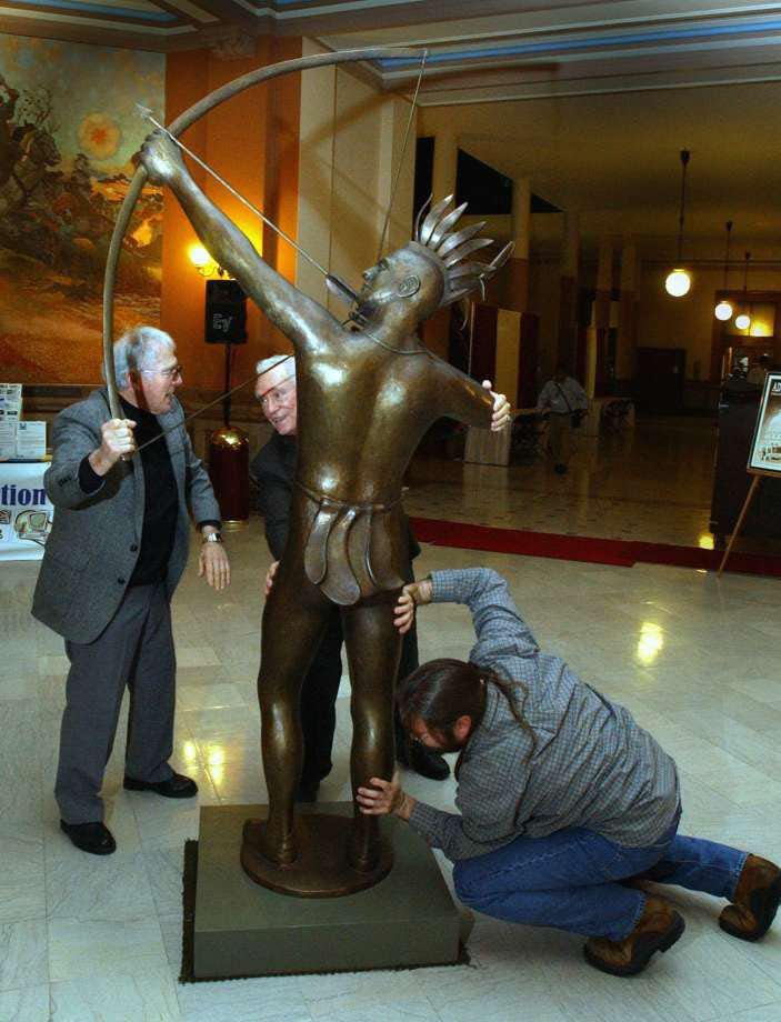 In this 2002 file photo, Salina sculptor Richard Bergen, from left, former state Sen. Ben Vidricksen and Bergen's son, Rich Bergen, slide an 8-foot-tall version of the Ad Astra statue into place in the rotunda of the Statehouse.