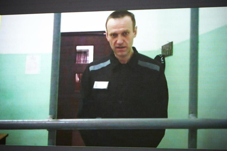 Russian opposition leader Alexei Navalny is seen on a TV screen as he appears in a video link provided by the Russian Federal Penitentiary Service from the colony in Melekhovo, Vladimir region, during a hearing at the Russian Supreme Court in Moscow, Russia, Thursday, June 22, 2023. Navalny has filed a lawsuit contesting prison regulations that, according to him, allow prison officials to deprive him of stationery and pens, thus violating his right to file complaints against them. (AP Photo/Alexander Zemlianichenko)