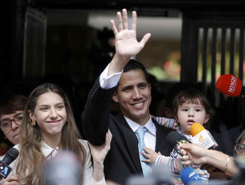 Self-declared interim president of Venezuela Juan Guaido, accompanied by his wife Fabiana Rosales and 20-month-old daughter Miranda, waves during a news conference outside their apartment, in Caracas, Venezuela, Thursday, Jan. 31, 2019. Guaido asserts that the constitution gives him the right as president of the opposition-controlled National Assembly to assume power from Nicolas Maduro after the Venezuelan leader banned opponents from running in an election last year that has been widely condemned as illegitimate. (AP Photo/Fernando Llano)