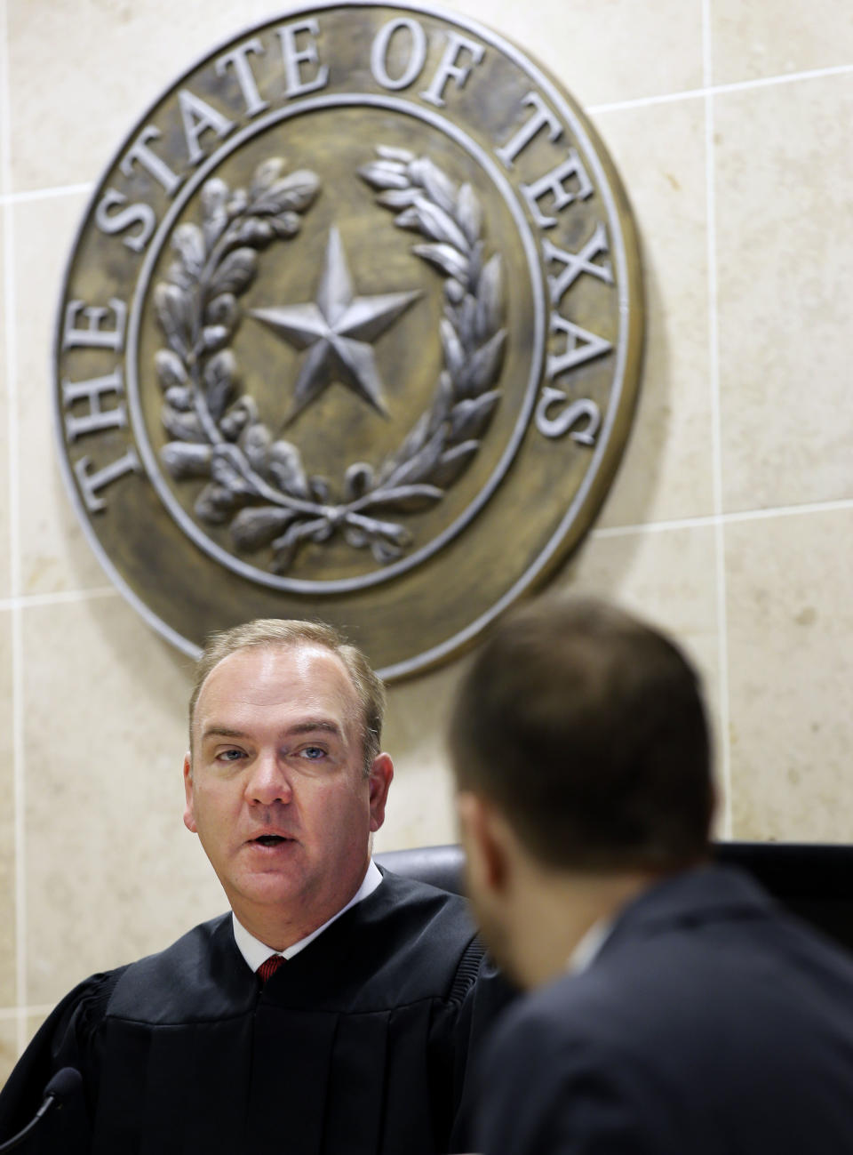 In this Thursday, Dec. 22, 2016 photo, Judge John Roach Jr., left, speaks to a lawyer during a hearing in McKinney, Texas. Rather than requiring veterans to travel to court appearances, Roach Jr.’s court travels to them. The traveling court serves veterans in five counties near Dallas who don’t have transportation. Veterans say the opportunity is life-changing. (AP Photo/LM Otero)