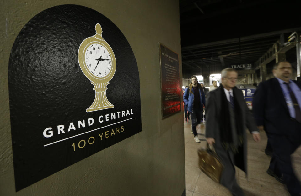 Passengers disembarking from a train pass a sign advertising the 100th anniversary of Grand Central Terminal in New York, Wednesday, Jan. 9, 2013. The country's most famous train station and one of the finest examples of Beaux Arts architecture in America turns 100 on Feb. 1. (AP Photo/Kathy Willens)