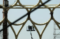 In this Oct. 8, 2019 photo, laborers work on a crane by the Al Wasl Dome at the under construction site of the Expo 2020 in Dubai, United Arab Emirates. (AP Photo/Kamran Jebreili)