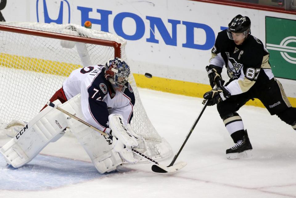 Pittsburgh Penguins' Sidney Crosby (87) cannot get his stick on the puck in front of Columbus Blue Jackets goalie Sergei Bobrovsky (72) during Game 5 of a first-round NHL playoff hockey series in Pittsburgh, Saturday, April 26, 2014. (AP Photo/Gene J. Puskar)