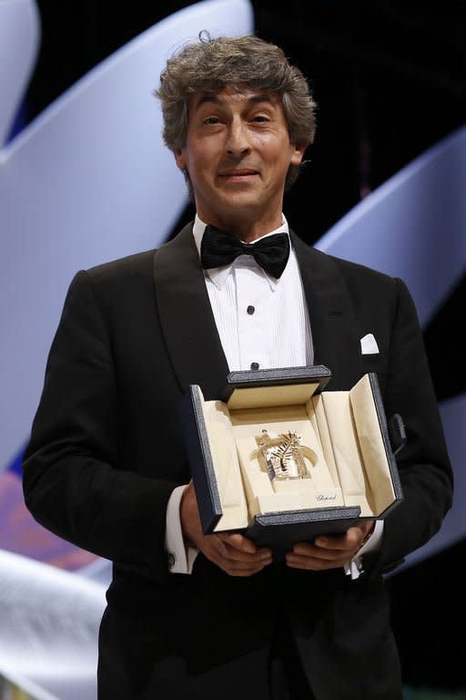 US director Alexander Payne poses on stage after he accepted the Prix d'Interpretation Masculine (best actor award) on behalf of US actor Bruce Dern during the closing ceremony of the 66th Cannes film festival on May 26, 2013