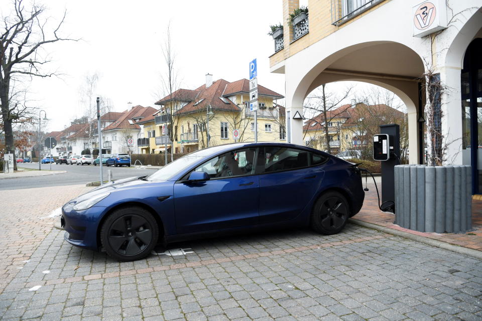 Električni automobil Tesla stoji na stanici za punjenje na tržnici u Gruenheideu, blizu Berlina, Njemačka, 28. prosinca 2021. REUTERS/Annegret Hilse