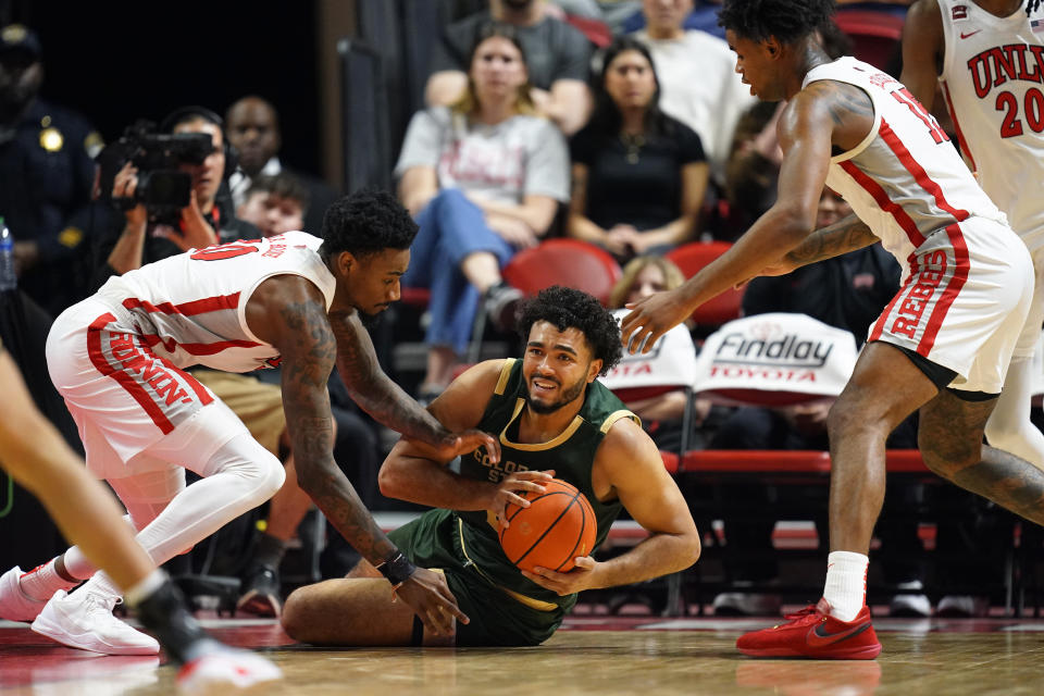 Colorado State forward Rashaan Mbemba (21) scrambles for the ball against UNLV guard Kalib Boone (10) and guard Luis Rodriguez (15) during the first half of an NCAA college basketball game Saturday, Feb. 24, 2024, in Las Vegas. (AP Photo/Lucas Peltier)