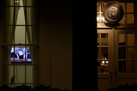 FILE PHOTO A television plays a news report on U.S. President Donald Trump's recent Oval Office meeting with Russia's Ambassador to the U.S. Sergei Kislyak as night falls on offices and the entrance of the West Wing of the White House in Washington, U.S. May 15, 2017. REUTERS/Jonathan Ernst/File Photo