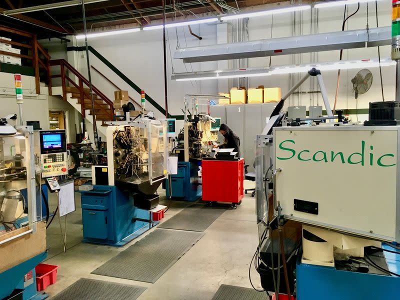 An operator programs a CNC wireforming machine to make a custom spring at Scandic Springs' factory in San Leandro