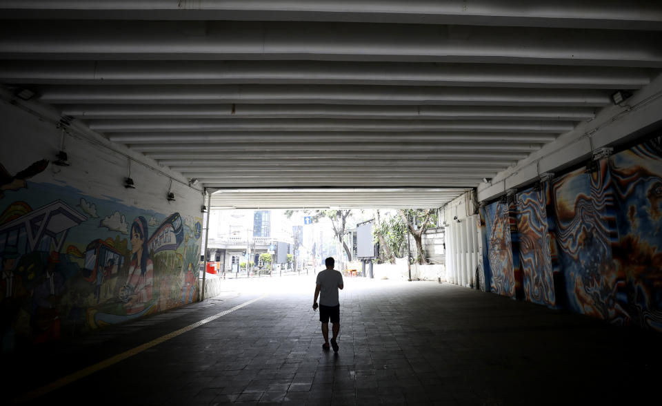 A man walks in a tunnel usually busy with pedestrians in the main business district in Jakarta, Indonesia, Friday, April 10, 2020. Mosques usually filled for Friday prayers and streets normally clogged with cars and motorcycles were empty as authorities in Indonesia's capital enforced stricter measures to halt the coronavirus' spread after deaths spiked in the past week. (AP Photo/Dita Alangkara)