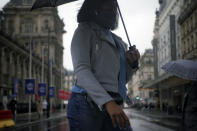 A woman wears a mask as she walks in a street of Paris, Tuesday, Oct. 27, 2020. France's government is holding emergency virus control meetings Tuesday and warning of possible new lockdowns, as hospitals fill up with new COVID patients and doctors plead for backup. (AP Photo/Thibault Camus)