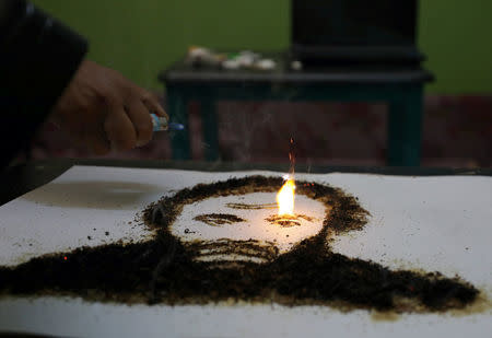 A portrait of the Egyptian actor Adel Imam made of tobacco by artist Abdelrahman al-Habrouk, burns in Alexanria, Egypt August 10, 2017. REUTERS/Mohamed Abd El Ghany
