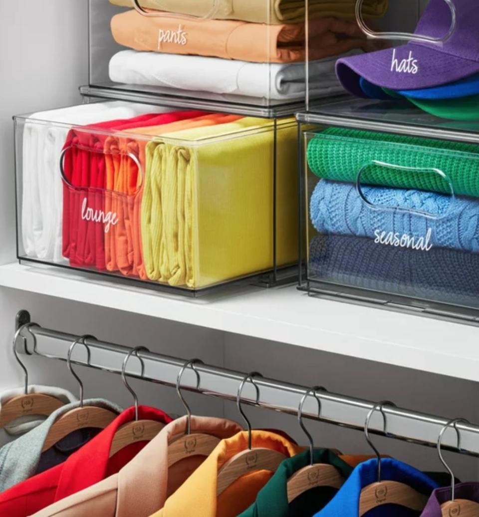clear storage bins filled with folded clothes in a closet