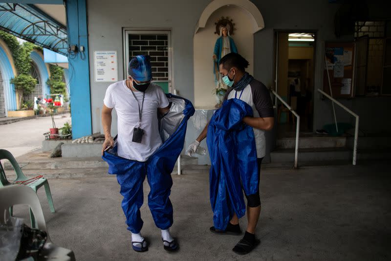 The Wider Image: Hazmat suits and holy water: two priests bring faith to Philippines lockdown