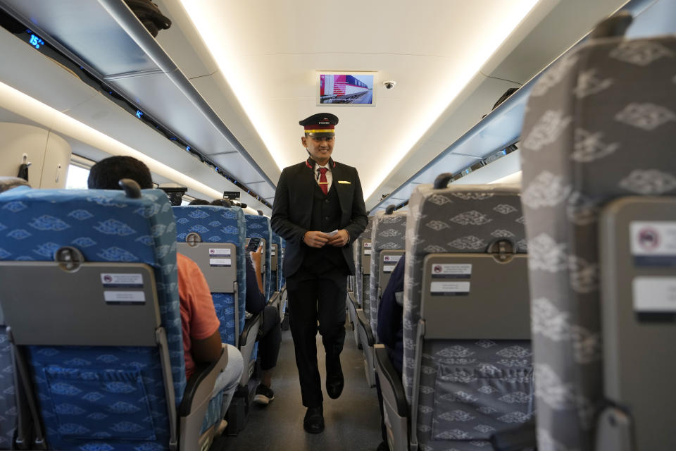 An official checks passengers of a high-speed train during a test ride from Bandung, West Java province, Indonesia, to Jakarta, on Sept. 18, 2023. Indonesia is launching Southeast Asia’s first high-speed railway, a key project under China’s Belt and Road infrastructure initiative that will cut travel time between the capital and another major city from the current three hours to about 40 minutes. (AP Photo/Achmad Ibrahim)