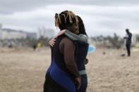 People hug after surfing at The Black Girls Surf paddle-out in memory of George Floyd, who died in Minneapolis police custody, in Santa Monica