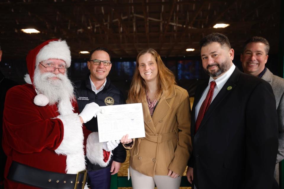 Governor Shapiro joined Secretary Redding, Dr. Alex Hamburg, and Santa Claus display certificate of clean bill of health for Santa's eight reindeers.