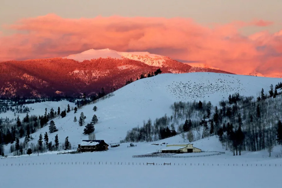 A ranch at the foothills of snowy mountains