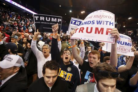 Trump supporters hold signs after Republican U.S. presidential candidate Donald Trump cancelled his rally at the University of Illinois at Chicago March 11, 2016. REUTERS/Kamil Krzaczynski