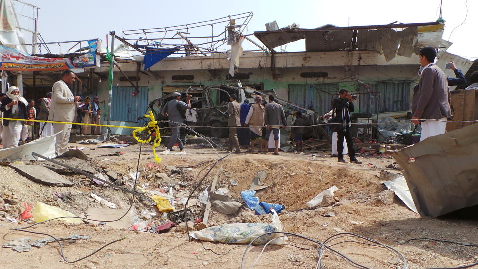 People gather at the site of an airstrike in Saada, Yemen on Friday, Aug. 10, 2018. Yemen's Shiite rebels are backing a United Nations' call for an investigation into a Saudi-led coalition airstrike in the country's north that killed dozens of people the previous day, including many children.(AP Photo/Kareem al-Mrrany)