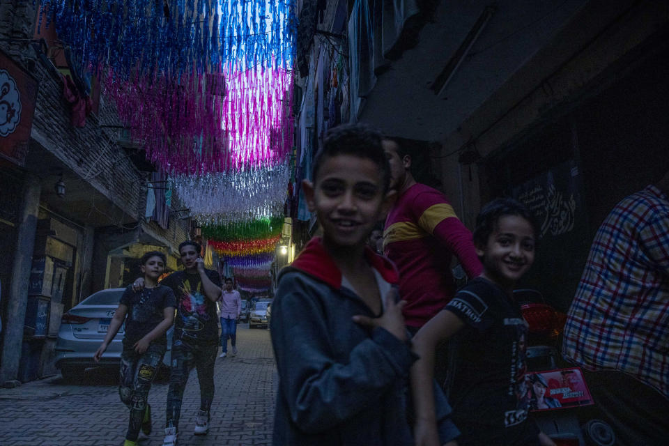 Children walk under decorations hung up for Ramadan a day ahead of the holy month, in the Imbaba neighborhood of Giza, April 23, 2020. Muslims around the world are trying to maintain the cherished rituals of Islam holiest month during the coronavirus pandemic. (AP Photo/Nariman El-Mofty)