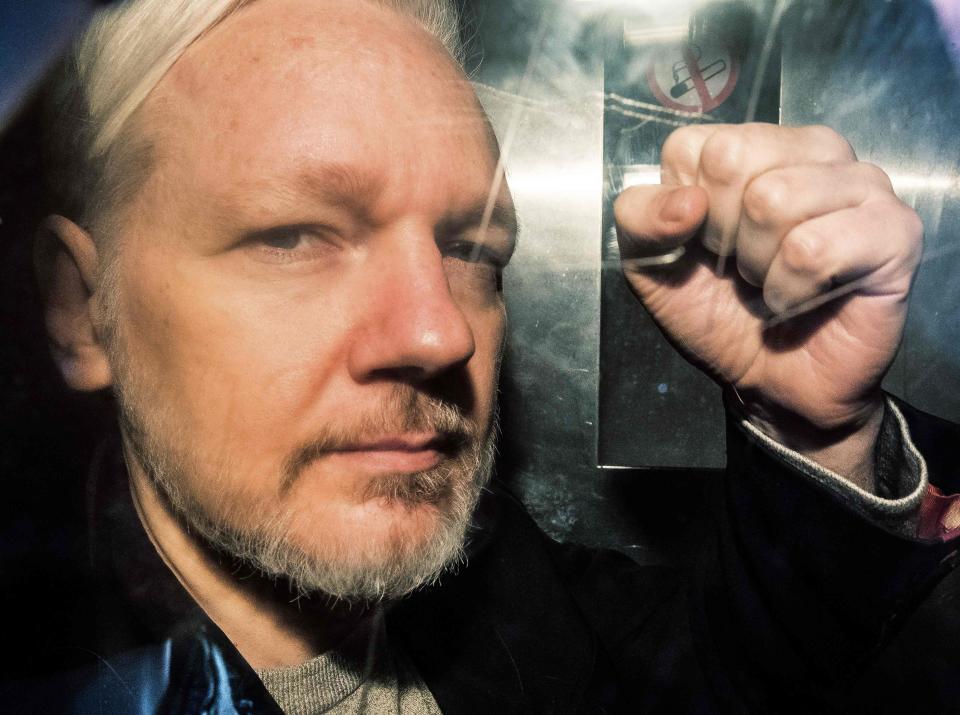 WikiLeaks founder Julian Assange gestures from the window of a prison van as he is driven into Southwark Crown Court in London on May 1, 2019.