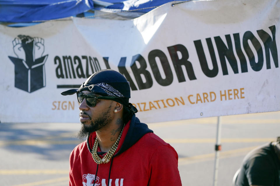 Chris Smalls, president of the Amazon Labor Union, stands by an information booth collecting signatures across the street from an Amazon distribution center in the Staten Island borough of New York, Thursday, Oct. 21, 2021. Federal labor officials say Amazon workers have lined up enough support to vote on whether to unionize a New York City warehouse. The National Labor Relations Board confirmed Thursday, Jan. 27, 2022 that the nascent Amazon Labor Union gathered enough signatures to hold an election. (AP Photo/Seth Wenig)