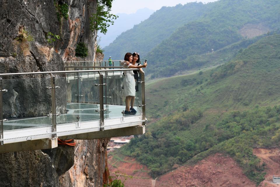 people stand on the Bach Long glass bridge in the Moc Chau district in Vietnam's Son La province