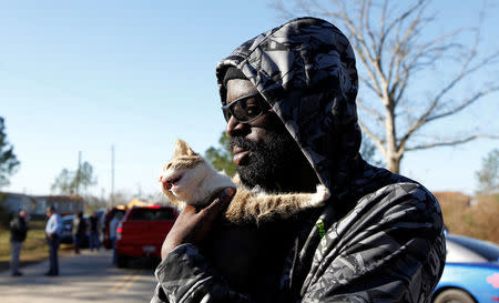 Resident Michael Lang holds Bella after rescuing her from his home at Sunshine Acres mobile home park after a tornado struck the Mobile Home Park in Adel, Georgia. REUTERS/Tami Chappell