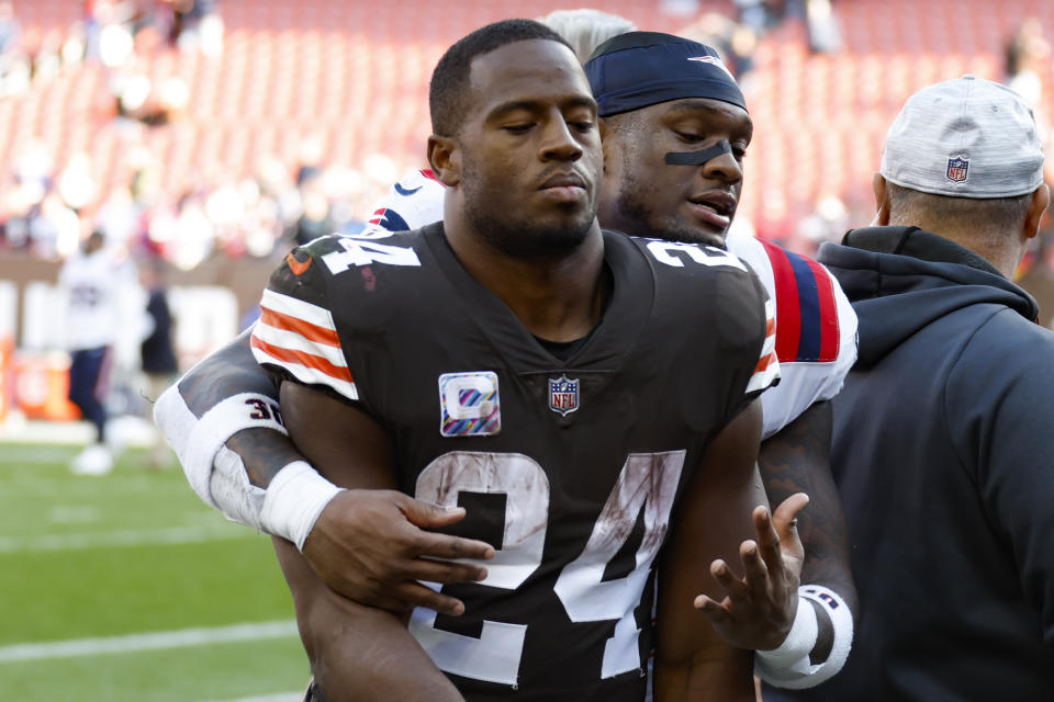 Cleveland Browns running back Nick Chubb (24) gets a hug from New England Patriots linebacker Mack Wilson Sr. as they leave the field after an NFL football game, Sunday, Oct. 16, 2022, in Cleveland. (AP Photo/Ron Schwane)