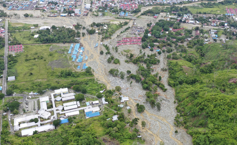 This aerial photo shows the area affected by flash floods in Sentani, Papua province, Indonesia, Monday, March 18, 2019. Flash floods and mudslides triggered by downpours tore through mountainside villages in Indonesia's easternmost province, killing dozens of people, disaster officials said. (AP Photo/Barce Rumkabu)