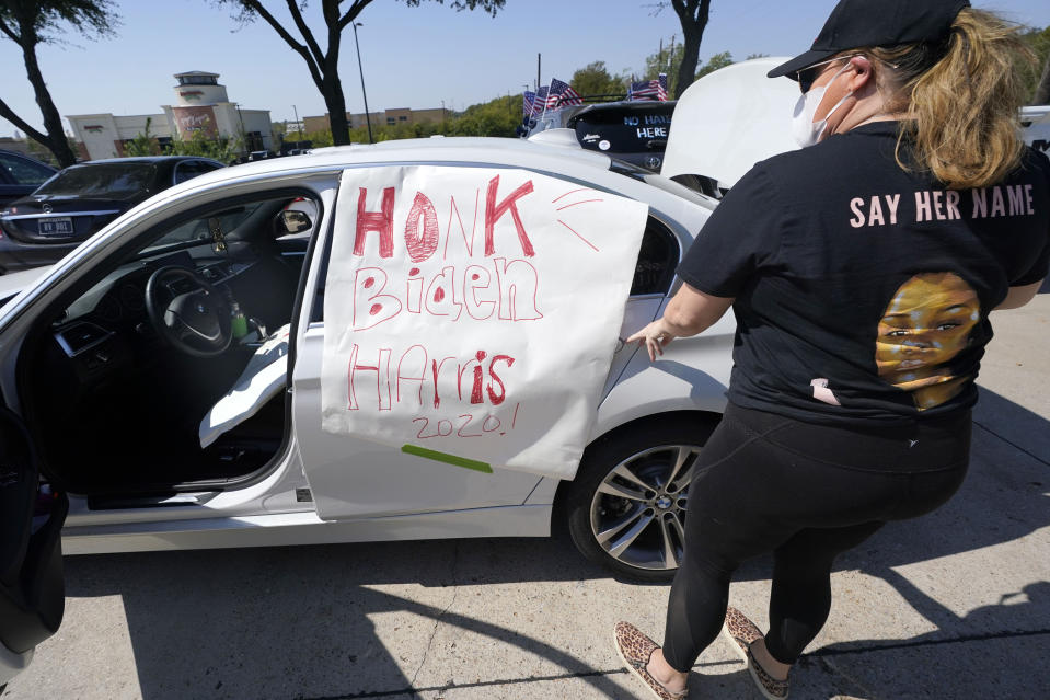 Michelle Lamont places her homemade sign on her car before a Ridin' With Biden event Sunday, Oct. 11, 2020, in Plano, Texas. Democrats in Texas are pressing Joe Biden to make a harder run at Texas with less than three weeks until Election Day. (AP Photo/LM Otero)