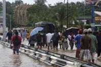 People walk through flooded streets in Acapulco September 17, 2013. Stranded tourists salvaged belongings from submerged cars in the Mexican beach resort of Acapulco which had become a floodplain on Tuesday after some of the worst storm damage in decades killed more than 50 people across the country. A three day downpour cut off several roads in Acapulco, wrecking cars and restricting the delivery of supplies to the Pacific port city of 750,000 people where the tourist trade has suffered in recent years from a surge in drug gang violence. REUTERS/Stringer