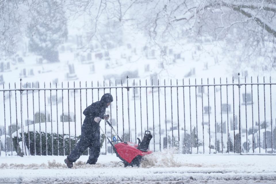 A person works to clear wet and heavy snow from a sidewalk during a winter storm in Philadelphia (Copyright 2024 The Associated Press. All rights reserved.)