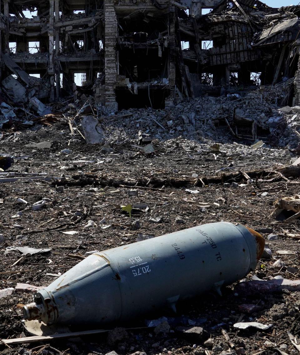 A non-exploded aviation bomb FAB-250 in front of a destroyed building in the city of Mariupol.