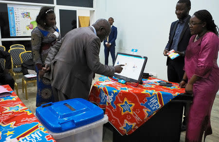 A man practices using an electronic voting machine