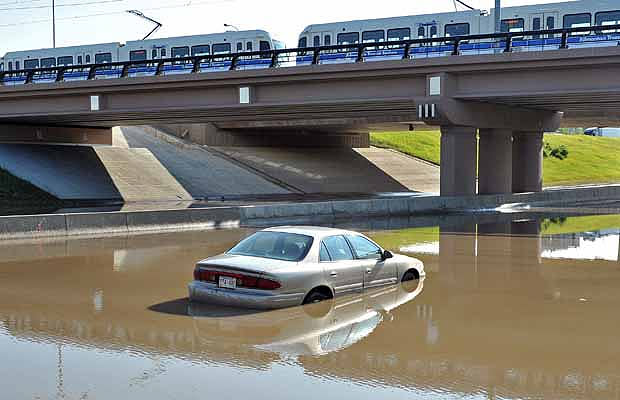 A car sits half submerged in water on Whitemud Drive beneath the 111th Street bridge after hail and heavy rain hit south Edmonton on July 12, 2012.