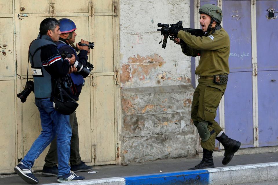 An Israeli soldier shouts as he aims his weapon during clashes with Palestinian demonstrators: REUTERS